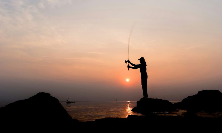 Silhouette of a man throwing a fishing rod